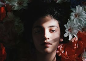 Captivating portrait of a woman with deep shadow and colorful flowers in Barranquilla.